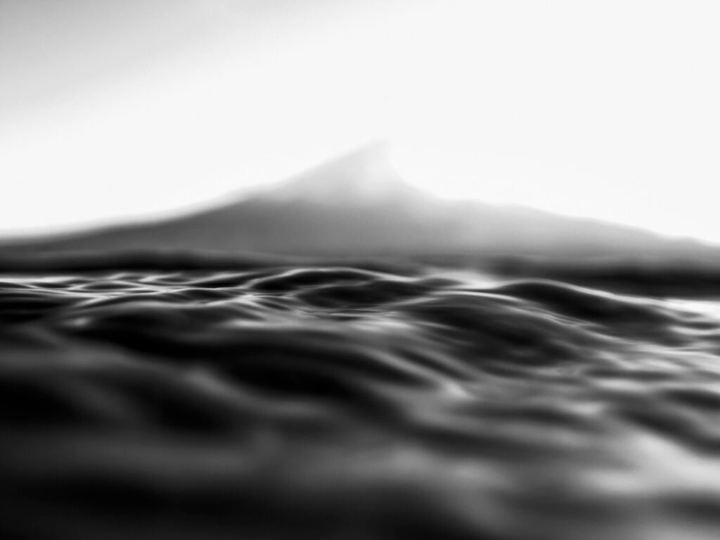 Rippling water in the foreground with a faint Mt. Fuji in the background, a serene monochrome expression of Japan’s impermanence and ephemeral beauty.